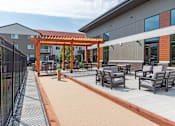 Thumbnail 23 of 30 - A patio with chairs and a pergola.