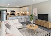 Thumbnail 2 of 30 - A modern living room with a white sofa, wooden coffee table, and a television.