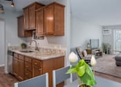Thumbnail 10 of 30 - a kitchen with wooden cabinets and a table with chairs