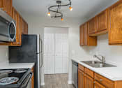 Thumbnail 6 of 30 - a kitchen with wood cabinets and white countertops