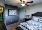 Thumbnail 4 of 10 - the master bedroom has a large bed and a ceiling fan