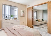 Thumbnail 4 of 18 - a bedroom with a bed and a door to a living room