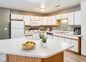 Thumbnail 1 of 18 - a kitchen with white cabinets and a bowl of fruit