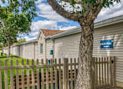 Thumbnail 12 of 18 - a row of houses with a fence and a tree
