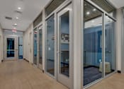 Thumbnail 20 of 28 - a corridor with glass doors and a wood floor
