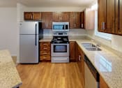 Thumbnail 3 of 21 - a kitchen with stainless steel appliances and wooden cabinets