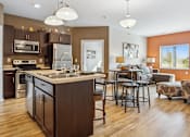 Thumbnail 1 of 27 - A modern kitchen with a large island and a dining area.