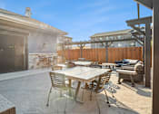 Thumbnail 14 of 27 - A patio with a table and chairs is shown.