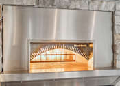 Thumbnail 19 of 27 - A wood stove with a metal frame and a glass door.