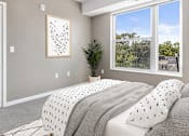 Thumbnail 9 of 31 - A bedroom with a large bed and a picture on the wall.