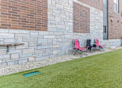 Thumbnail 25 of 31 - Two red chairs are placed on a green lawn.