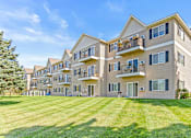 Thumbnail 4 of 14 - a large apartment building with balconies and a lawn