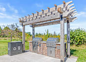 Thumbnail 8 of 14 - a pergola with three trash bins in a park