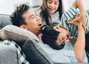 Thumbnail 6 of 23 - a father plays with his son and daughter on the couch