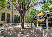 Thumbnail 1 of 16 - Angled image of FreightYard building exterior of exposed brick with large tree in front.