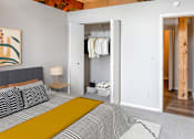 Thumbnail 12 of 16 - a bedroom with a bed and a closet