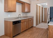 Thumbnail 18 of 20 - an empty kitchen with wooden cabinets and a stainless steel dishwasher