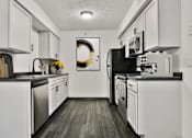 Thumbnail 1 of 20 - Kitchen with Appliances, White Cabinets and Dark Hard Wood Flooring