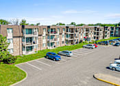 Thumbnail 17 of 18 - an aerial view of an apartment complex with cars parked in a parking lot