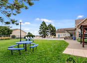 Thumbnail 16 of 24 - a patio with picnic tables and a pool in the backyard of a house