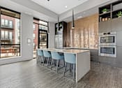 Thumbnail 15 of 36 - A modern kitchen with a long island and stools.