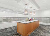 Thumbnail 14 of 36 - A reception desk with a white counter and a brown wooden frame is in the middle of a room with grey carpeting and white walls.