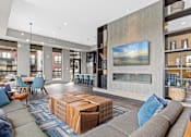 Thumbnail 2 of 36 - A modern living room with a grey sofa, a wooden coffee table, and a large painting on the wall.