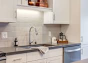 Thumbnail 5 of 36 - Bright kitchen with white cabinetry and Cesar Stone Quartz countertops.