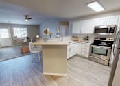 Thumbnail 11 of 33 - Renovated kitchens feature white cabinetry, stainless steel appliances, and open concept layout.