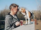 Thumbnail 26 of 33 - Image of a man and his Beagle dog smiling happily. We are a pet friendly community with a dog park.