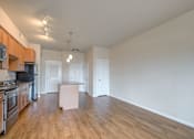 Thumbnail 15 of 20 - a kitchen and living room with hardwood floors and white walls