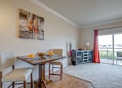 Thumbnail 12 of 20 - a dining area with a table and chairs and a sliding glass door leading to a balcony