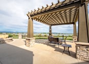 Thumbnail 9 of 20 - a patio with a pergola and a view of the water