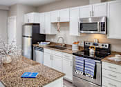 Thumbnail 2 of 20 - a kitchen with stainless steel appliances and granite counter tops