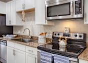 Thumbnail 1 of 20 - a kitchen with stainless steel appliances and white cabinets
