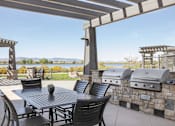 Thumbnail 8 of 20 - a patio with a table and chairs and a grill