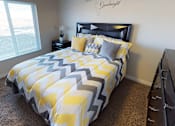 Thumbnail 7 of 15 - a bedroom with a yellow and gray comforter on a bed