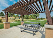 Thumbnail 29 of 40 - Outdoor picnic area underneath a pergola near the private walking path.