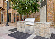 Thumbnail 41 of 54 - A silver outdoor grill is on a stone wall.