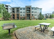 Thumbnail 46 of 54 - Picnic table and bench in front of apartment building.