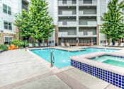 Thumbnail 24 of 53 - A large swimming pool surrounded by apartment buildings.