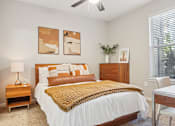 Thumbnail 7 of 53 - A bedroom with a bed, nightstand, and a ceiling fan.
