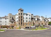 Thumbnail 47 of 53 - A large apartment complex with a parking lot in front.