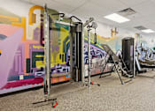 Thumbnail 31 of 53 - A gym with a row of treadmills and a row of stationary bikes.