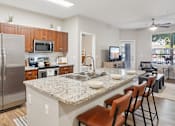 Thumbnail 1 of 53 - A kitchen with a granite countertop and stainless steel appliances.