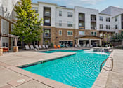 Thumbnail 22 of 53 - A large swimming pool in front of apartment buildings.