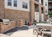 Thumbnail 21 of 40 - an outside patio with a grill and a table with chairs