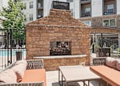 Thumbnail 20 of 40 - a courtyard with a stone fireplace and tables and chairs