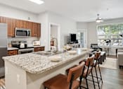 Thumbnail 13 of 40 - an open kitchen and living room with a granite counter top