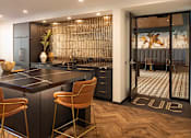 Thumbnail 38 of 40 - a kitchen with a large island and a bar with chairs